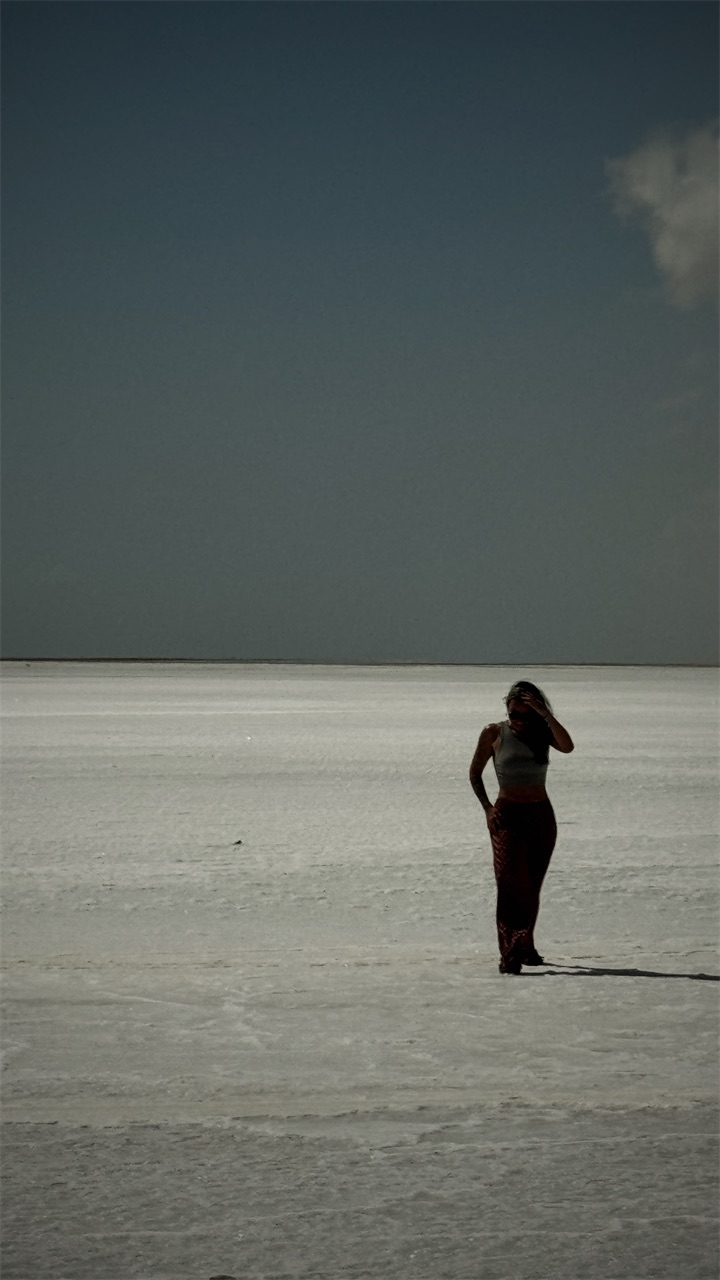 Cristiana on a white salt flat under a dark sky