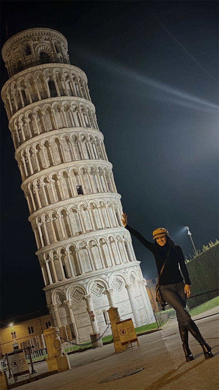 Cristiana pretending to hold up the Leaning Tower of Pisa at night